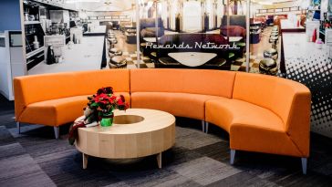 Orange couch in a sitting area in the Rewards Network office