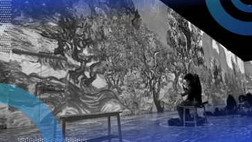 Two people sit on a bench and experience the Van Gogh immersive art exhibit. /blockchain/exhibiting-nft-digital-art