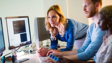 Programmers and business people collaborating in company office