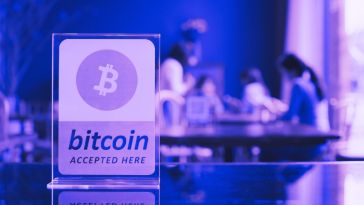 Purple bitcoin "accepted here" sign.
