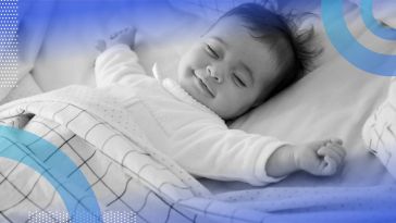 A smiling baby spreads out while sleeping