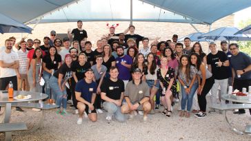 The GetSales team poses for a group photo on a beach at a crawfish boil