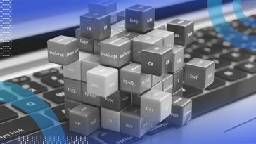 A stack of cubes with programming language names sits on a laptop keyboard