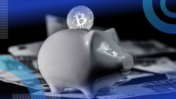 A Bitcoin being slotted into a piggy bank.
