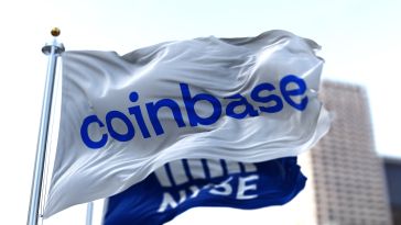 A flag bearing the Coinbase logo flys in front of a flag bearing the logo of the New York Stock Exchange