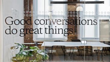 A glass door of a meeting room at OpenWeb. The door has "Good conversations do great things" printed on it.