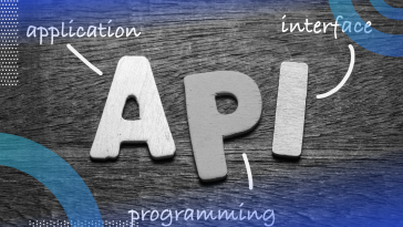 API image of the letters API on a wooden table. There are arrows to each corresponding word spelling out the acronym, application programming interface