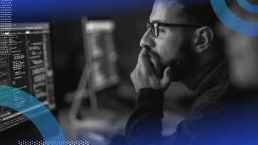 Software requirement specification image of a bearded man wearing glasses holding his chin and looking at a screen as though studying or reading something