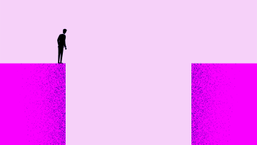 A person standing on one endo of a large gap looking down into it.