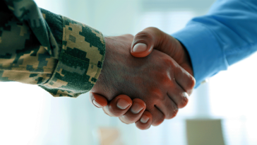 A veteran shaking hands with an employer hiring them for a job.