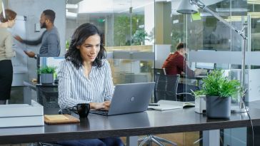 Office workers work in a bright open office environment