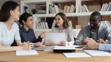 Four people sit around a table with papers 