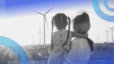 A woman and little girl look at wind turbines
