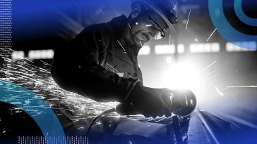 Industrial worker cutting metal, sparks flying