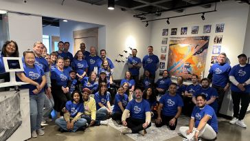 The Zeta team poses in blue t-shirts