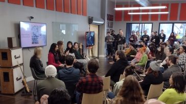 Reverb employees gathered around to watch a panel discussion during Ensemble Week.