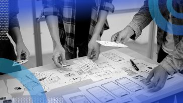 Three people captured from the elbow down putting together wireframes of a product on paper.
