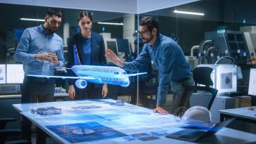 Group of engineers gather around a hologram of a commercial airliner. 