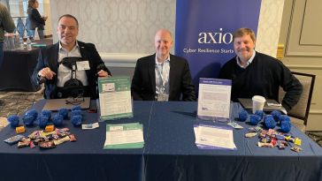  Axio leaders at a branded conference booth