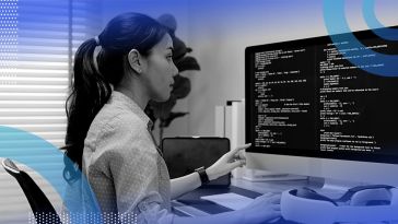A woman works at a computer terminal full of code