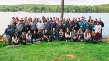 Team members gather outdoors for a group photo to commemorate the 2022 company retreat. 