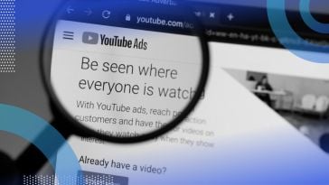 A magnifying glass enlarging the YouTue Ads homepage on a computer.