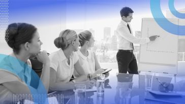 A man gives a presentation to his coworkers at a whiteboard