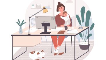 mother juggling baby while working at a computer