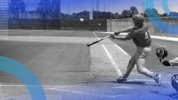 A baseball player swinging at a ball on a baseball field with a catcher behind him.