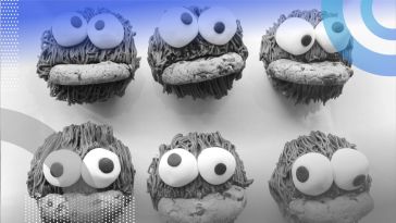 Six Cooke Monsters with googly eyeballs are eating cookies .