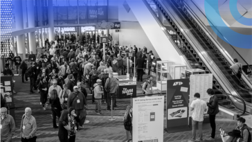 Hundreds of people are walking around at a tech conference.