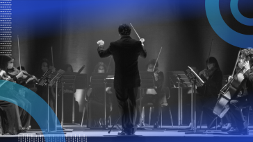 The back of a conductor conducting an orchestra.