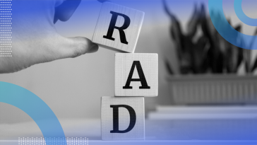 A close-up of someone stacking blocks on top of each other that spell RAD.