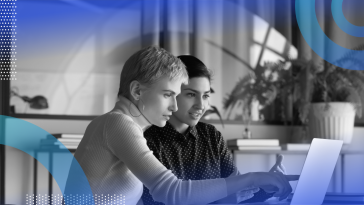 Two women leaders are sitting at a computer and talking.