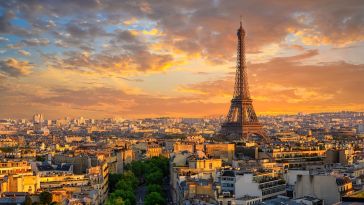 Skyline of Paris at sunset with Eiffel Tower visible. 