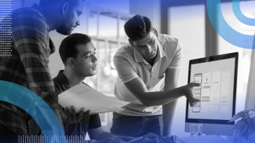 Three people are looking at a computer screen that shows a prototype app