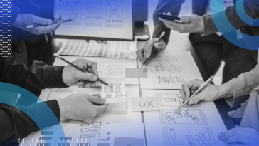 A close-up of three peoples’ hands pointing at hand-drawn mobile app sketches with pens and pencils.