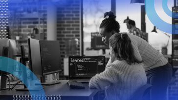 Two developers looking over a python error on a laptop