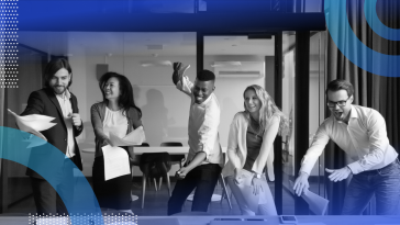 Five salespeople are standing around a table and celebrating a win.