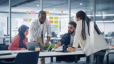 Product managers working on a project at a table in their office.