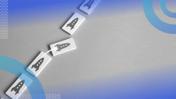 Five domino-shaped rectangles lined up with rocketships printed on them. The middle rocketship rectangle is taking off toward the right, out of the line.