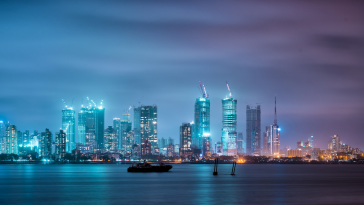 The Mumbai skyline aglow with the lights of the city on a dusky night.