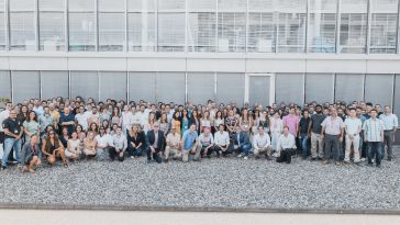 The SOPHiA GENETICS team poses for a large group photo outside their office.