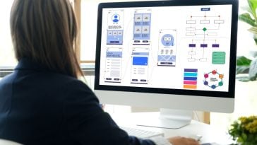 person looking at wireframes on screen