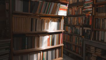 books on library shelves with light shining down on them