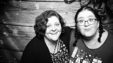 Heather Prince (left) poses with a colleague in a black-and-white photo booth picture.