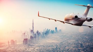 A plane flies over a city.