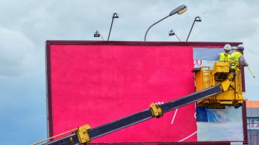 worker installing billboard