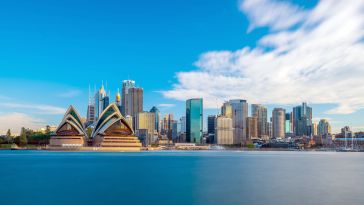 A skyline view of Sydney featuring several skyscrapers behind the Sydney Opera House.