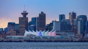 A view of the downtown Vancouver skyline featuring several tall buildings along the water.